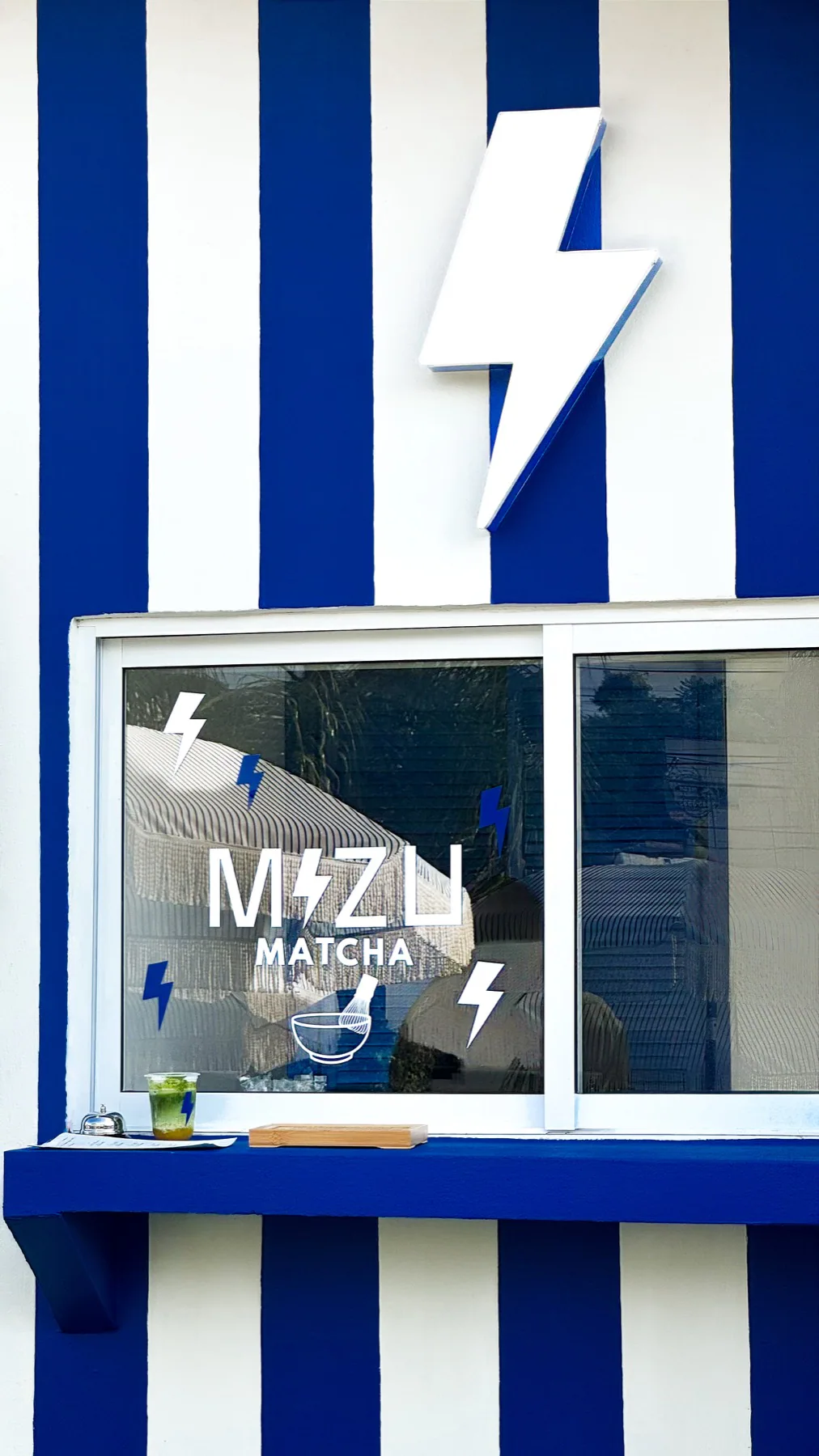 Fachada azul y blanca de Mizu Matcha en Zona Real